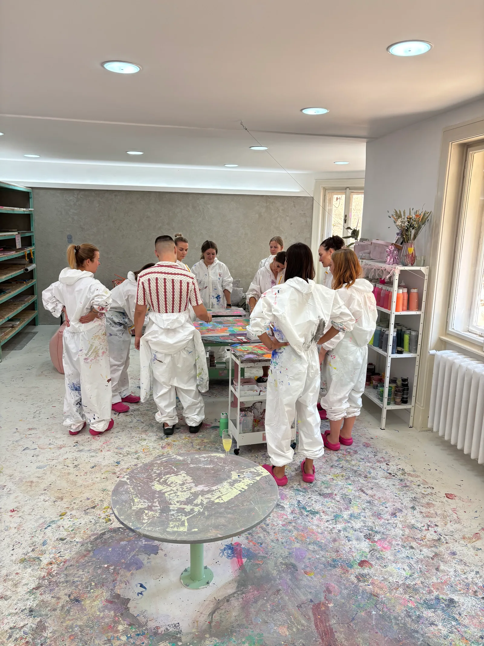 Group of visitors in protective overalls during a painting technique demo at No Limit Art Brno